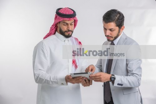 Arab Businessmen standing using the device|