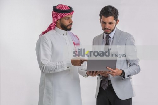 Arab Businessmen standing using the laptop|