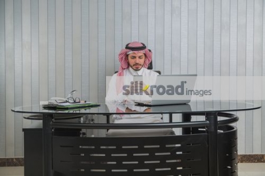 Businessman texting sitting at the office desk|