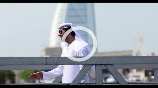 Arab man standing by the dock saying hello to his friend|