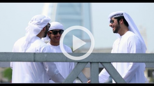 Arab men standing by the dock talking to each other|