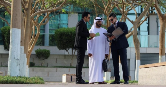 Colleagues standing talking to each other|-
