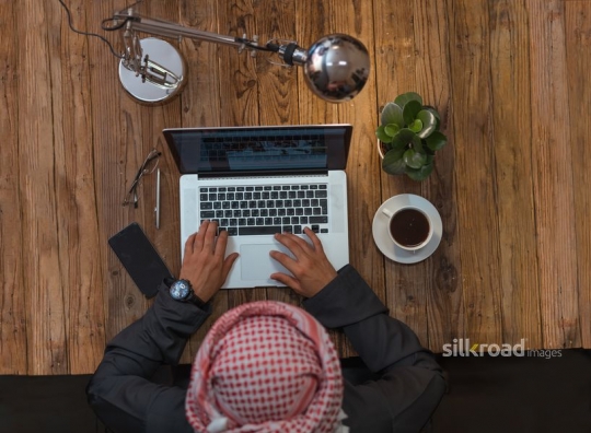 Top view of a man working late behind his laptop