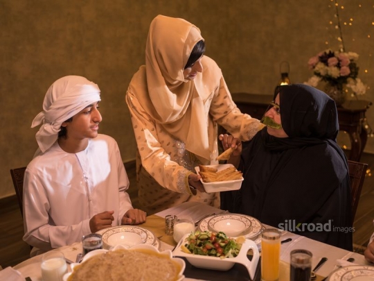 Mother serving food to grandmother|-