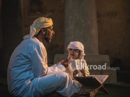 Boy praying with grandfather at the mosque|-