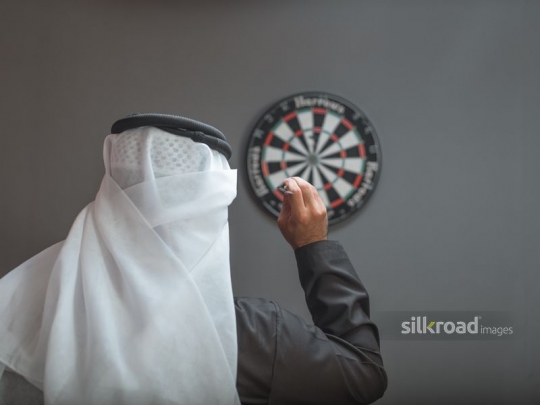 Man aiming at dart board