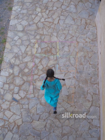 Girl playing hopscotch|-