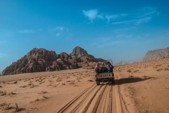 car in a huge desert of wadi rum