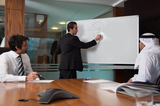 business people sitting on presentation at office with a businessman drawing to whiteboard