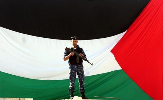 soldier standing in front of palestinian flag