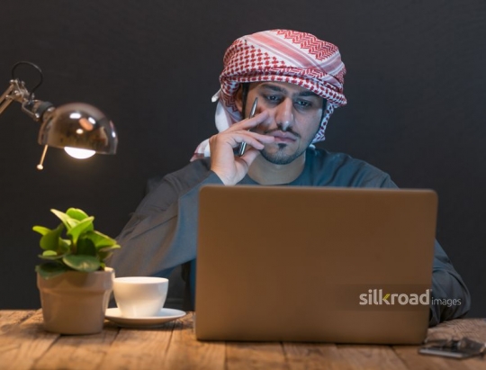 Young man working up late