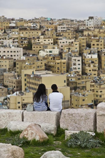 young couple setting on rock