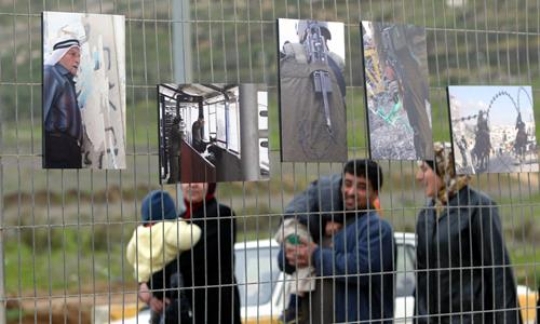 photo hanging on hawara checkpoint fence