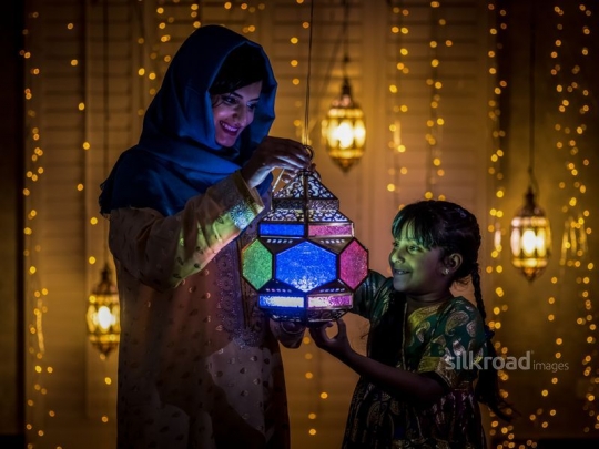 Mother with daughter carrying lantern|-