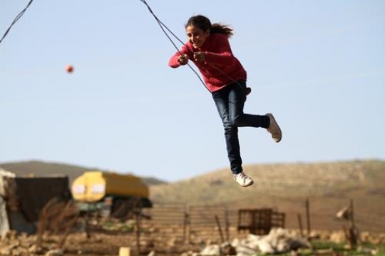 Cute girl is playing with her brothers and swing