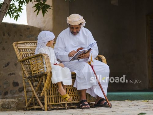 Grandfather reading qur'an with grandson|-