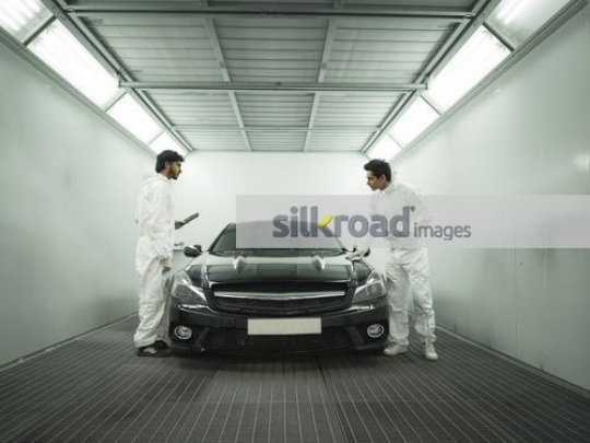 Workers checking car at the workshop|