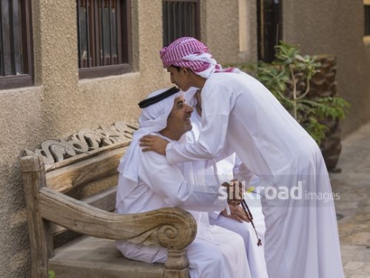 Arab son kissing grandfathers head|-