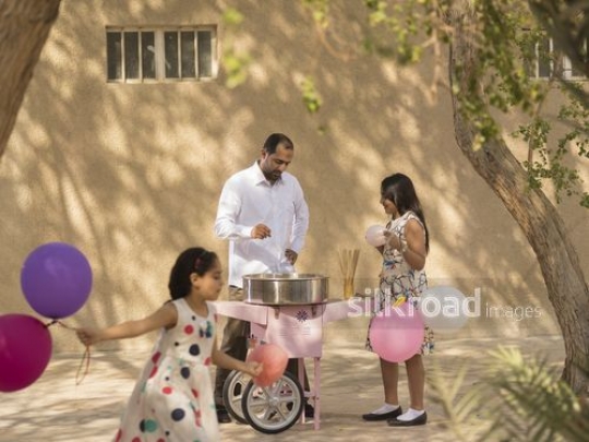 Arab father talking to his daughter while the girl is running around|-