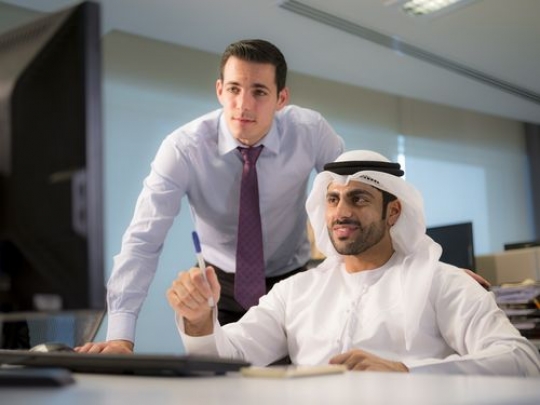 Business people exchanging ideas about work while looking at the computer|