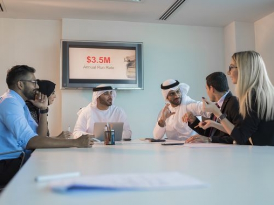 Business men and business women during an update meeting|-