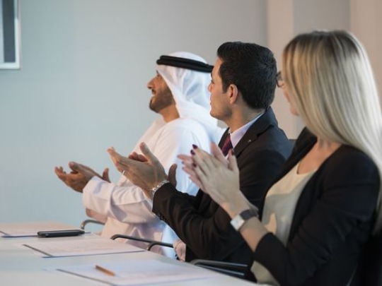 Employees clapping hands during a meeting