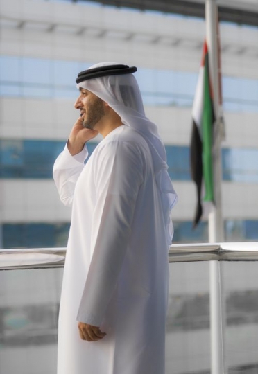 Side view of a Businessman talking on the phone on the balcony|-