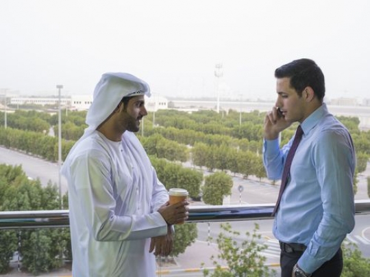 Two employees having a break outside at the balcony|-