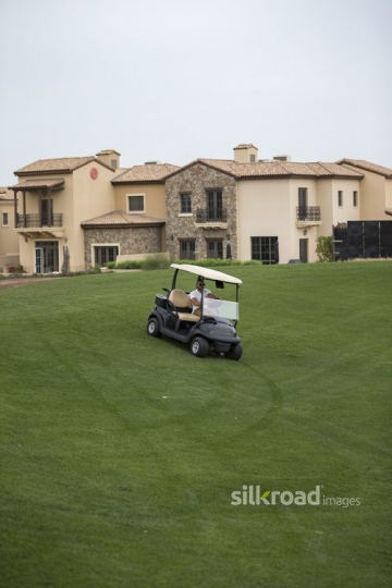 Arab man driving around the Resort with the Golf Cart|-