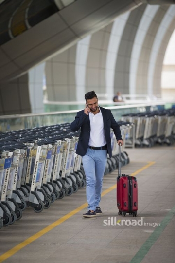 Arab man walking outside of the airport|-