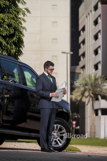 Western Businessman standing still with a newspaper|-