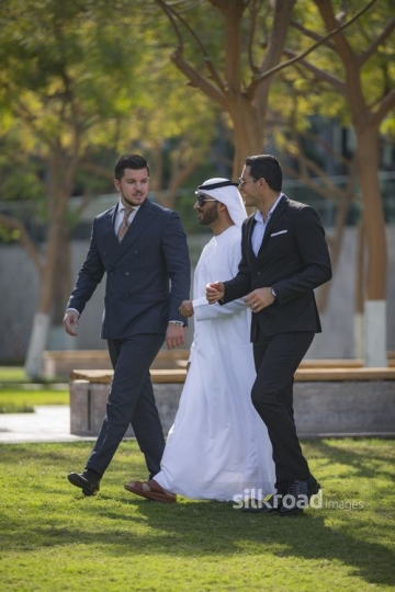 Three Businessmen walking next to each other outside |-