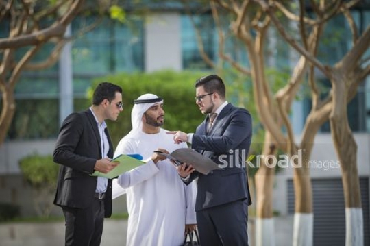 Three Businessmen standing talking to each other|-