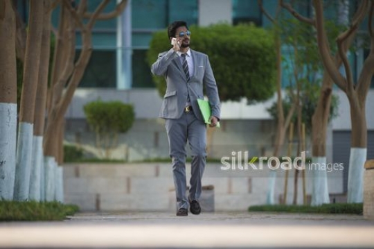 Businessman dressed in a suit talking on the phone|-