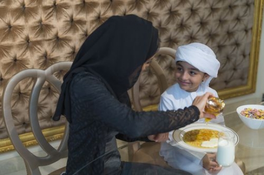 Middle eastern mother preparing her sons breakfast|-