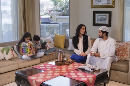 Middle eastern family sitting together|-