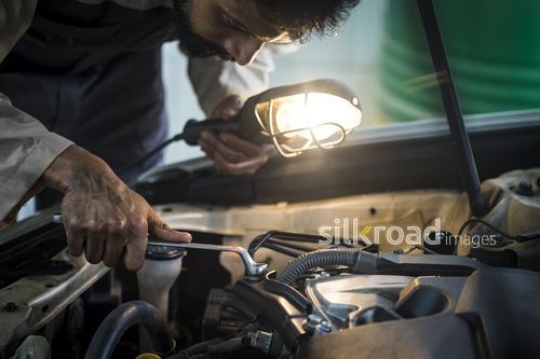 Mechanic Worker screwing a part for the car|-