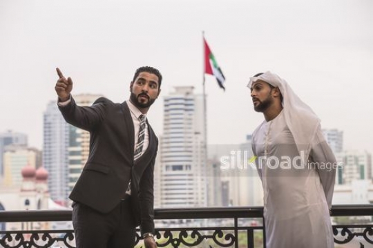 Middle Eastern men standing talking to each other|-