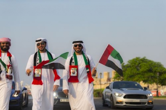 Emirati men participating in a National Day parade|-