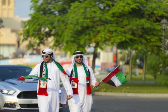 Arab men dressed in the traditional attire celebrating the UAE national Day|-
