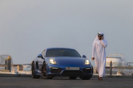 Arab man walking away from luxury car while talking on the phone|-