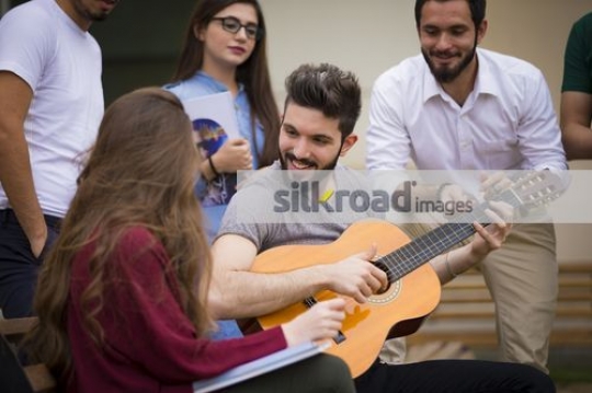 Middle Eastern man playing on the guitar|