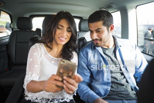 Two people sitting the car taking a selfie|-