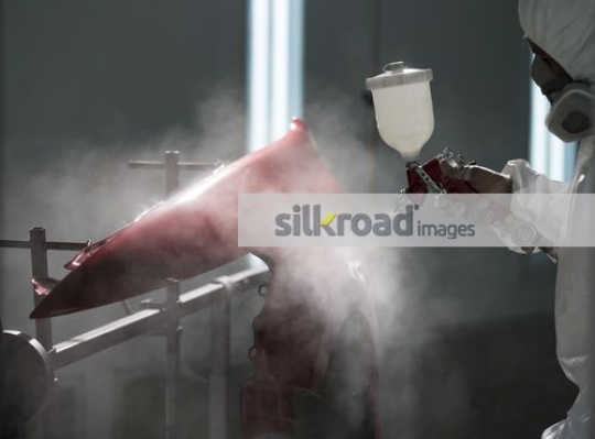 Painting the part of the car the color red|