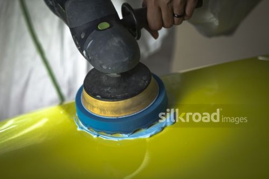 Man cleaning the yellow car with machine|-
