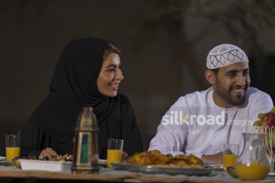 Arab man and woman sitting together at the dinning table|-