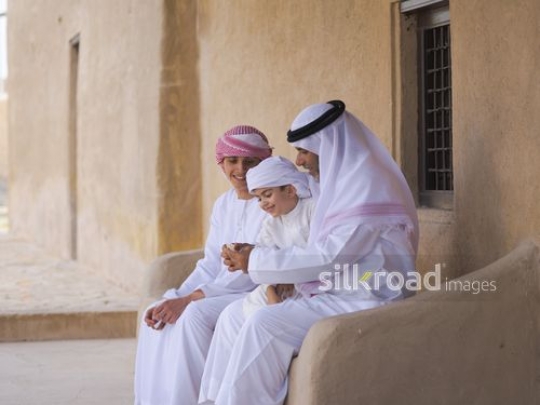 Boys with grandfather sitting outside|-