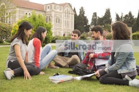 University Students talking on the grass together |