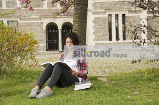 Woman sitting on campus studying|