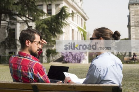 University students sitting on the bench together |